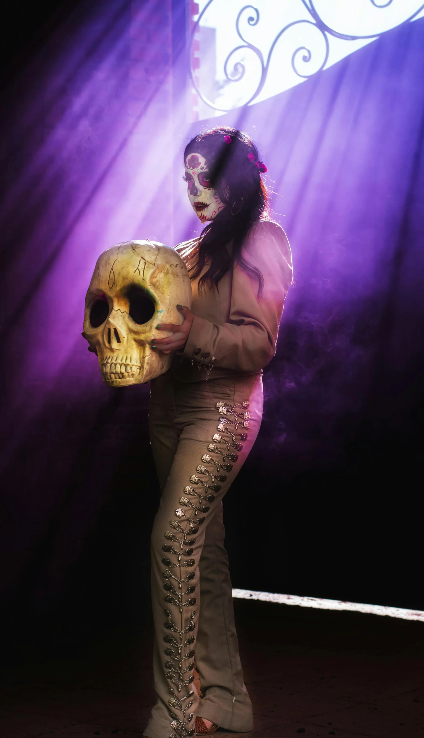 the woman in the costume is holding a skull