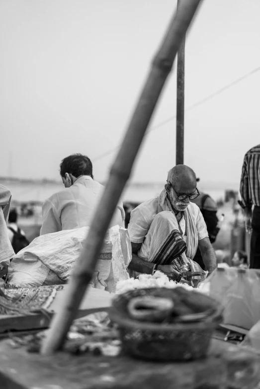 a man sitting next to another person under an umbrella