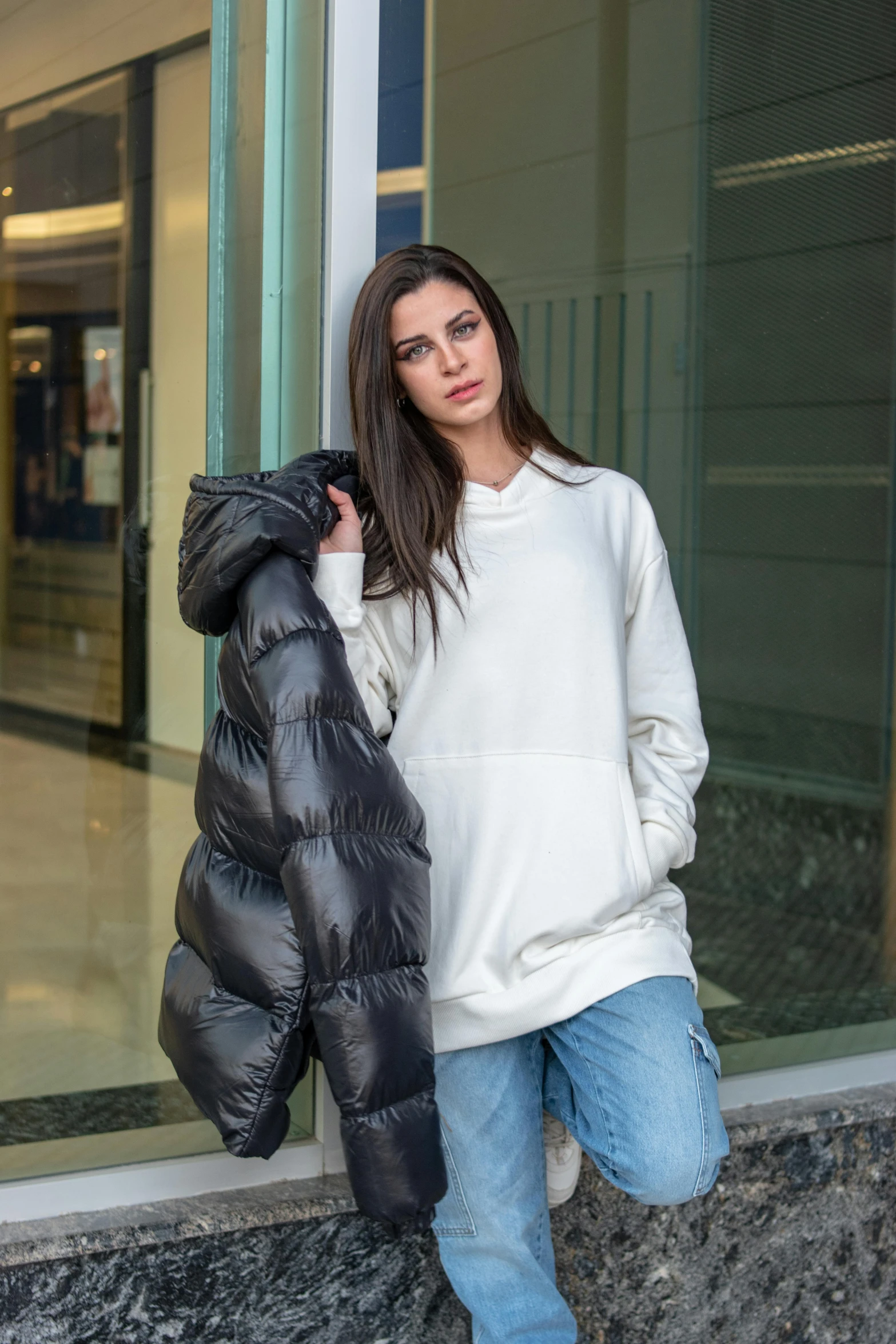 a young woman standing on the side walk