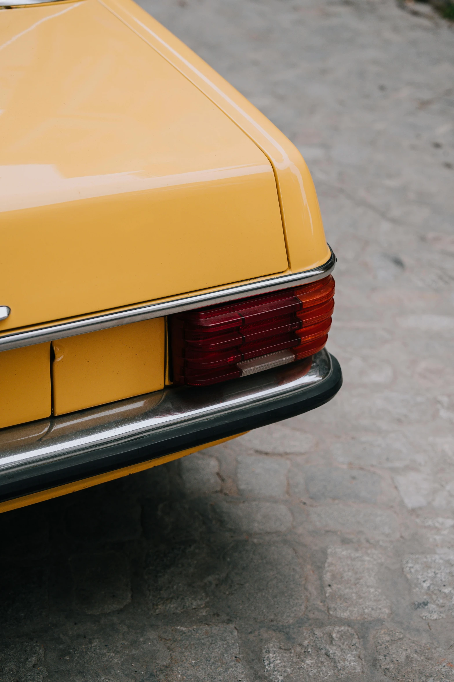 the rear end of an old yellow car