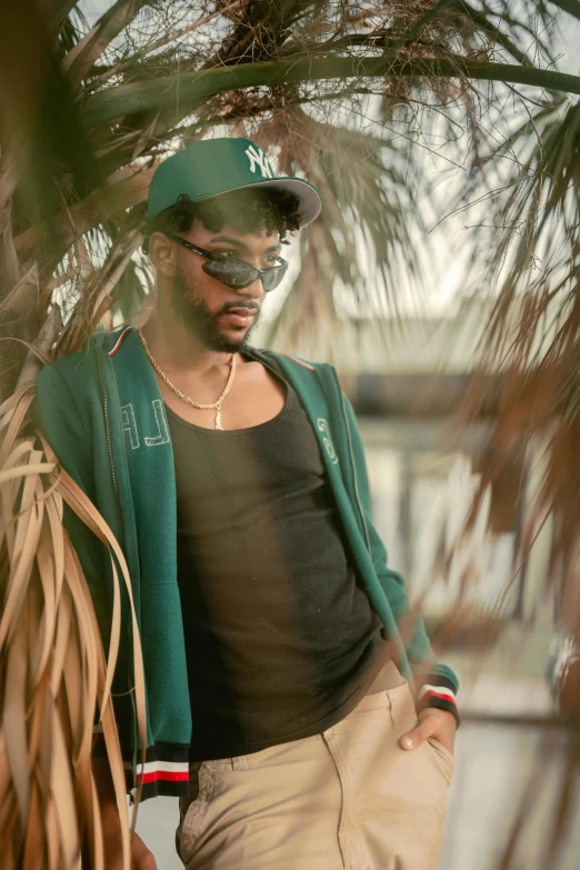 a man wearing a baseball cap standing under a tree