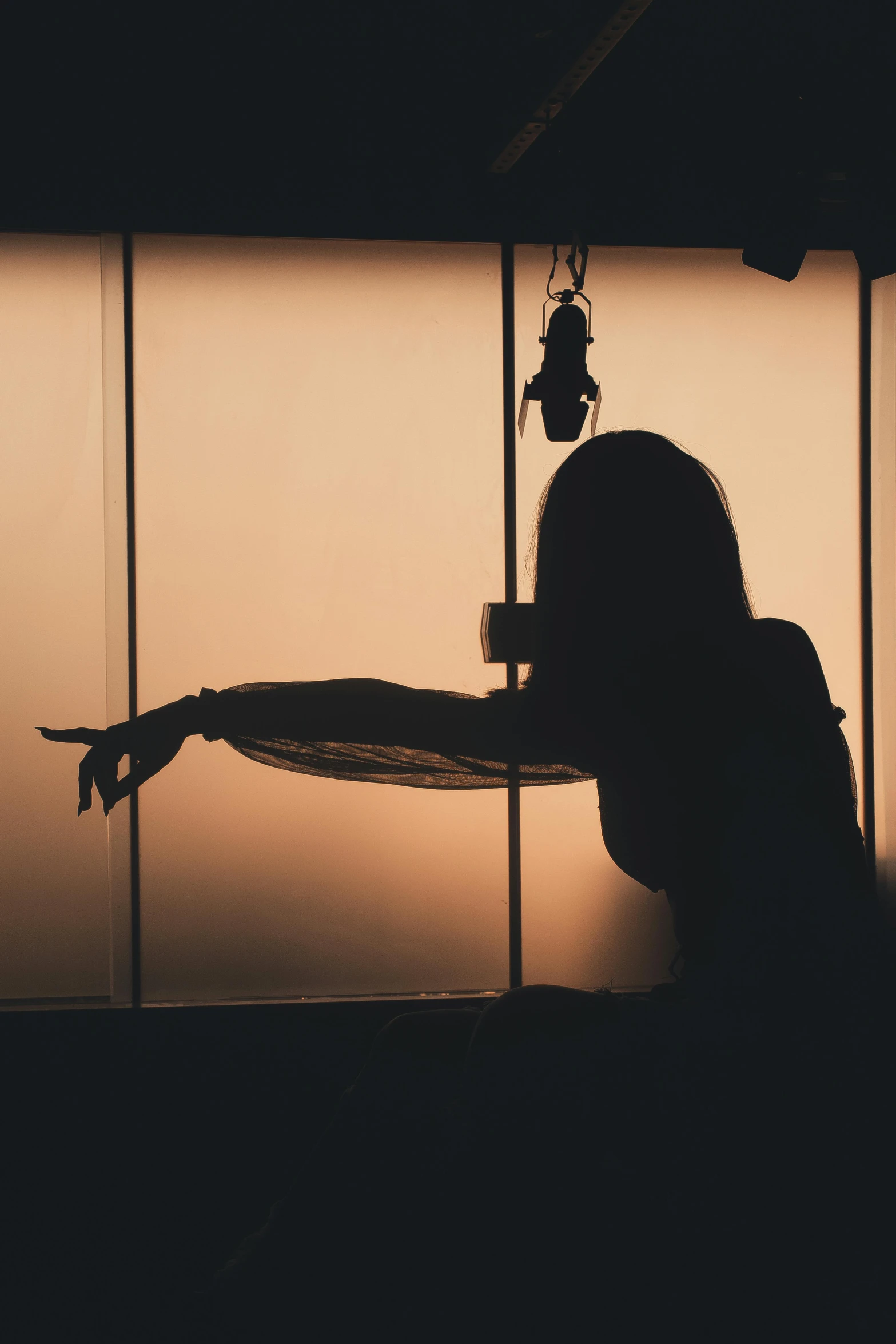 silhouette of woman by window in dark room