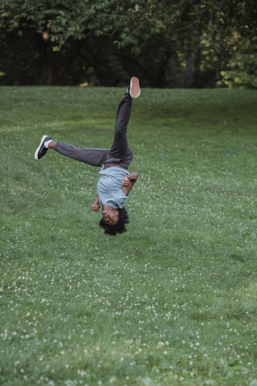 a person diving to retrieve a frisbee on grass