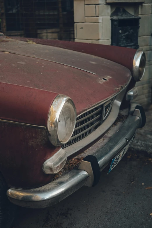 the front end of an old rusted classic car