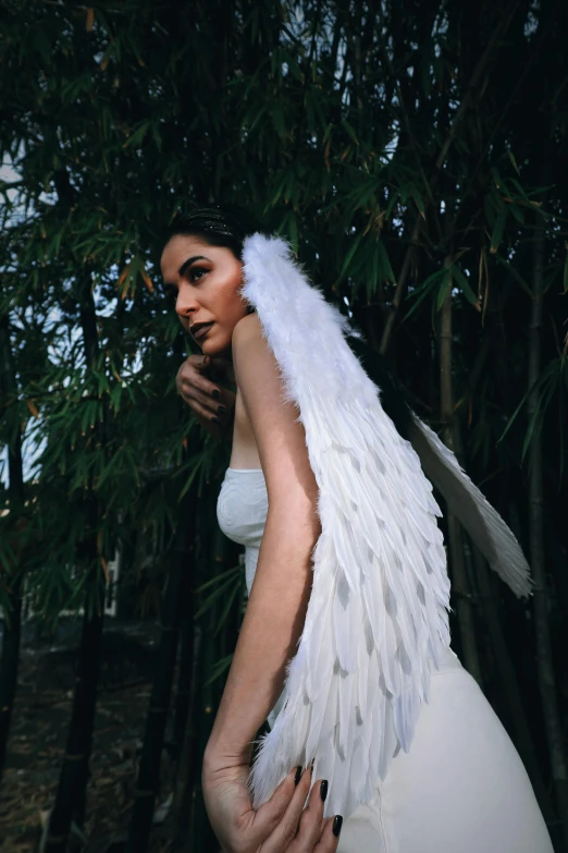 a woman wearing a fake angel wing in the forest