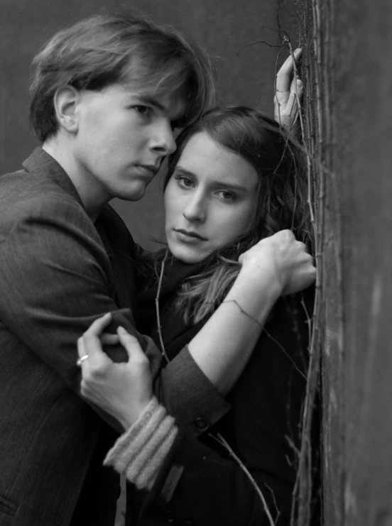 a boy and girl hugging each other for a black and white portrait