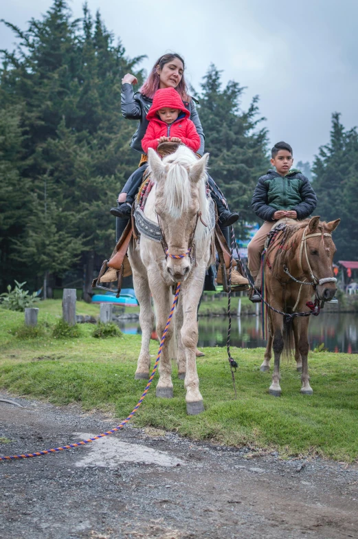 two people are riding a horse on the road