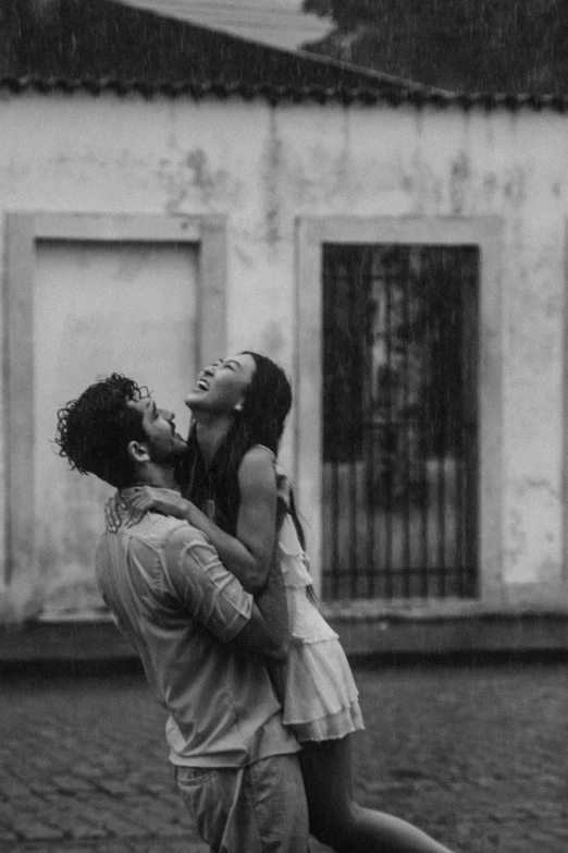 two people standing next to each other in front of an old building