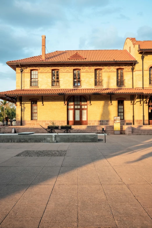 a yellow house with a tiled front yard and front entrance