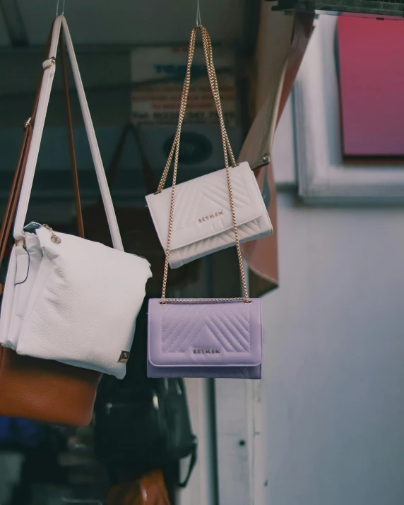 four different types of purses are hanging up in a rack