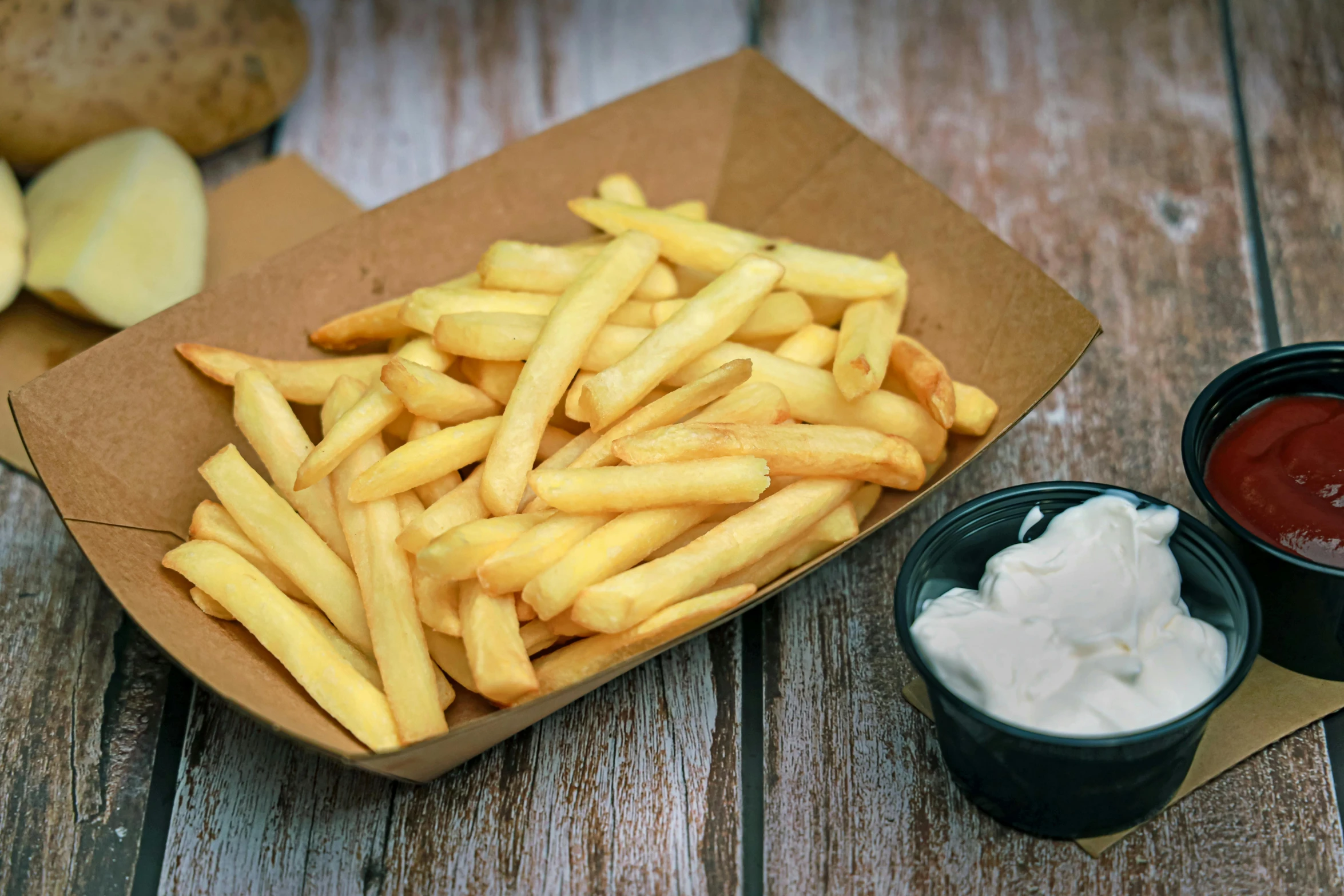 a tray that has some fries and dipping sauces