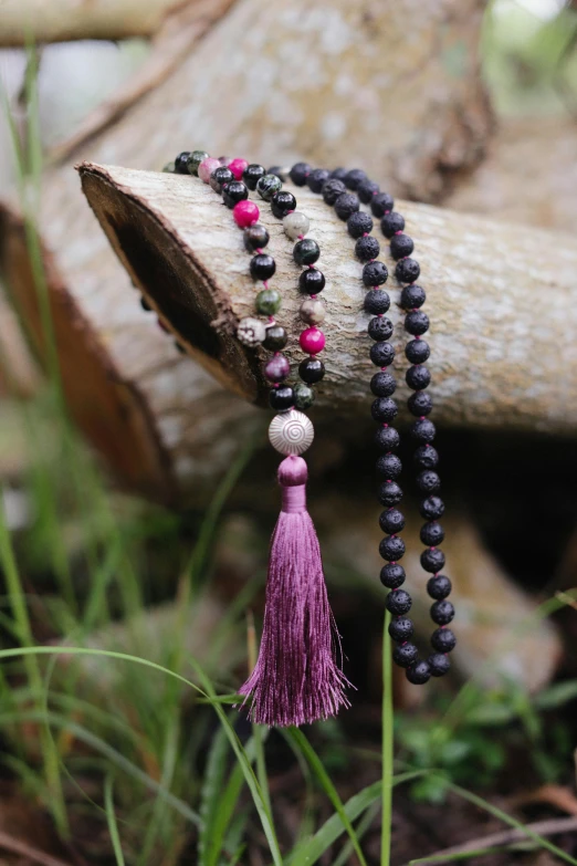 a celet with red beads and tasseled beads