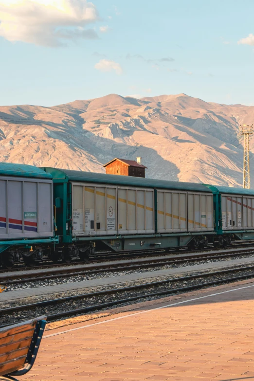 a green train engine with carts down a track