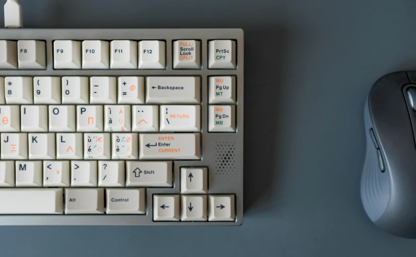 a white and orange keyboard and a silver mouse