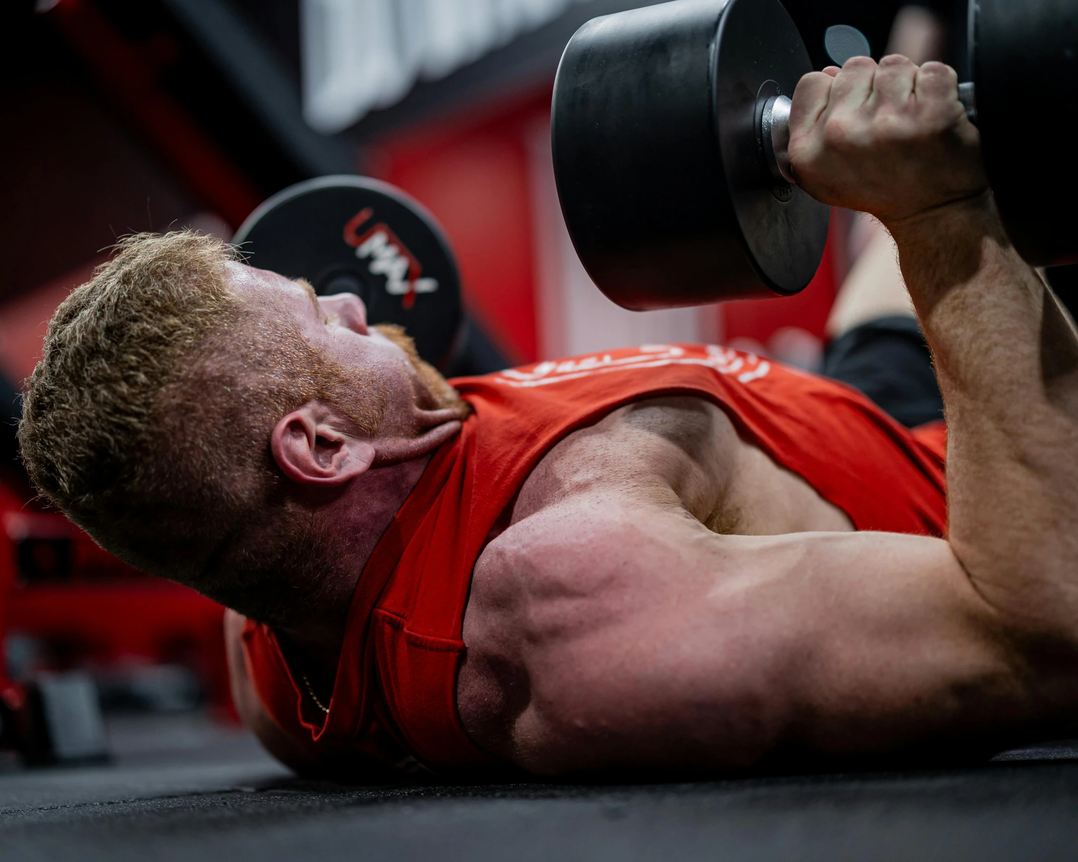 a man laying on the ground with his hand in a gym