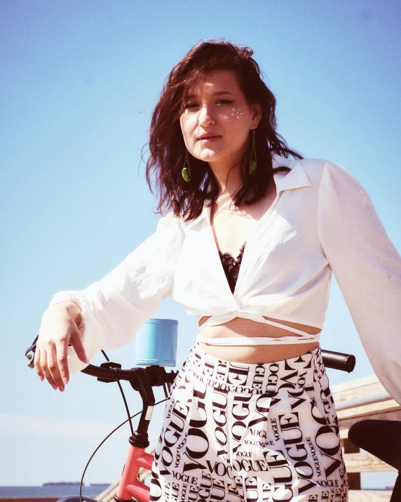 woman in a white shirt is posing with a bicycle