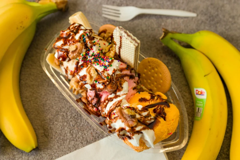 a banana split in a plastic container on the ground with other banana's