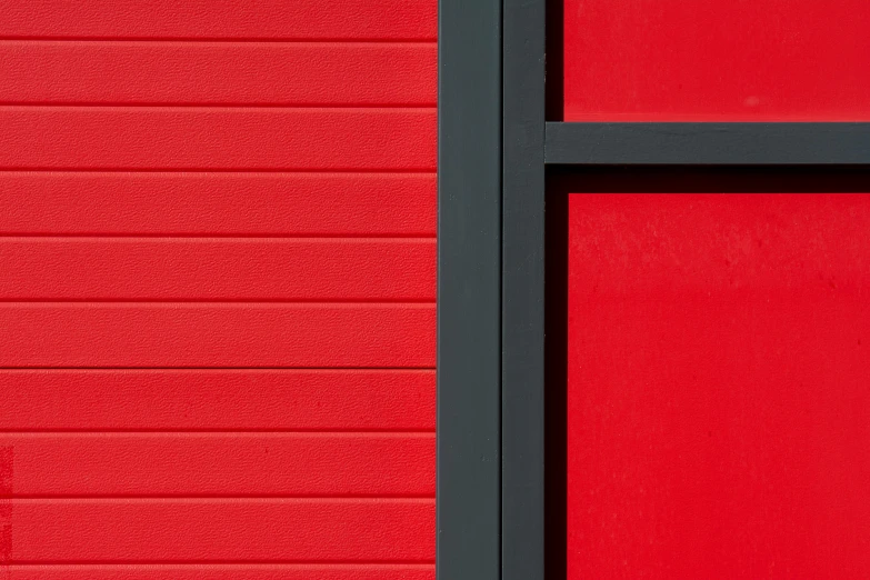 a red metal door and window are close together