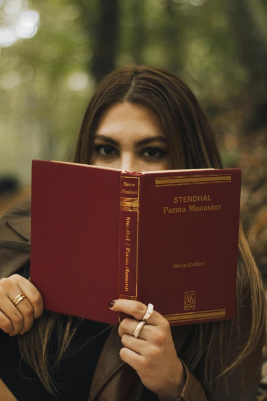 the girl is holding a red book with her hands