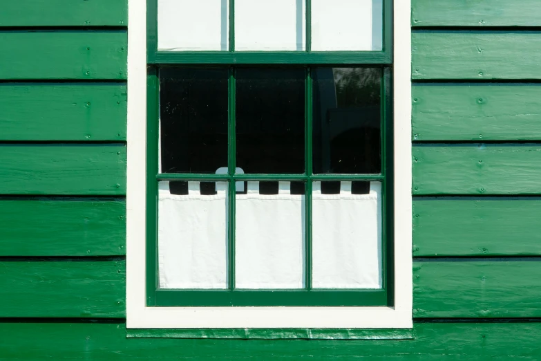 a green and white window with a striped white ribbon