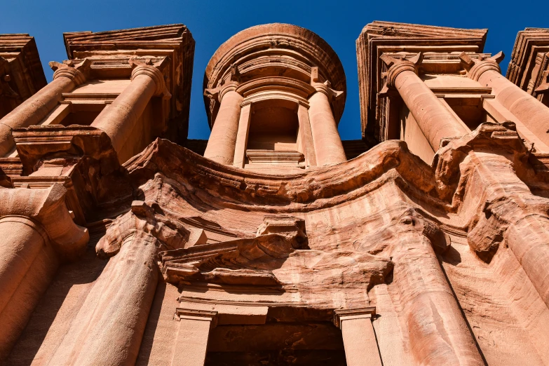 looking up at a very tall old building that looks to be a temple