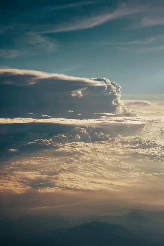 a group of clouds in the sky with a plane flying overhead