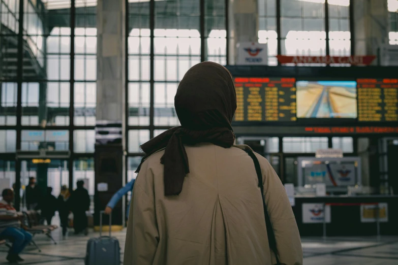 person in brown jacket waiting at terminal area