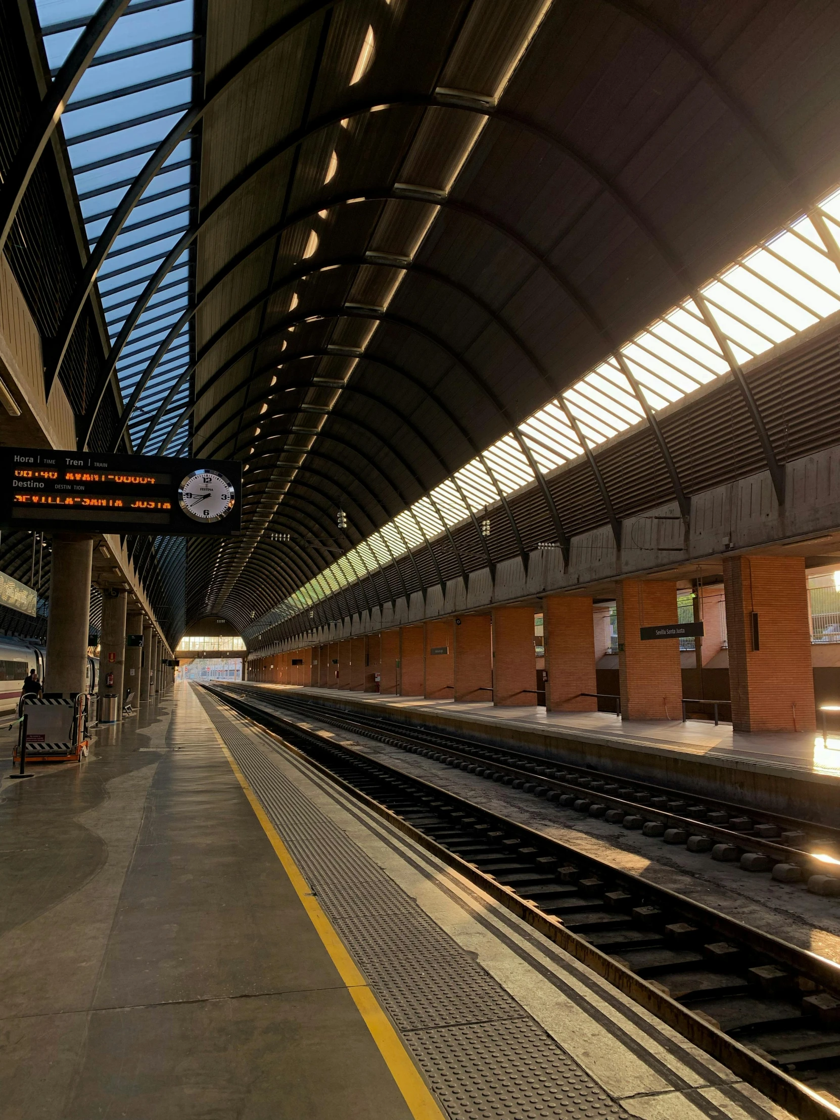 the view of a train platform, showing a ceiling in a very large area