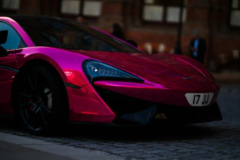 the pink sports car is parked on the road