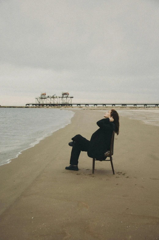 a person sitting on a beach chair near the ocean