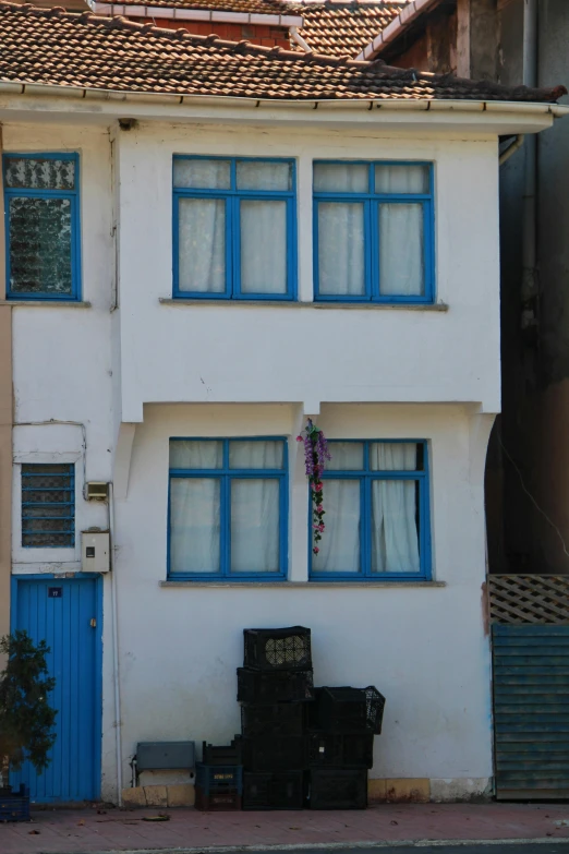 a white building with blue windows and a bench in front