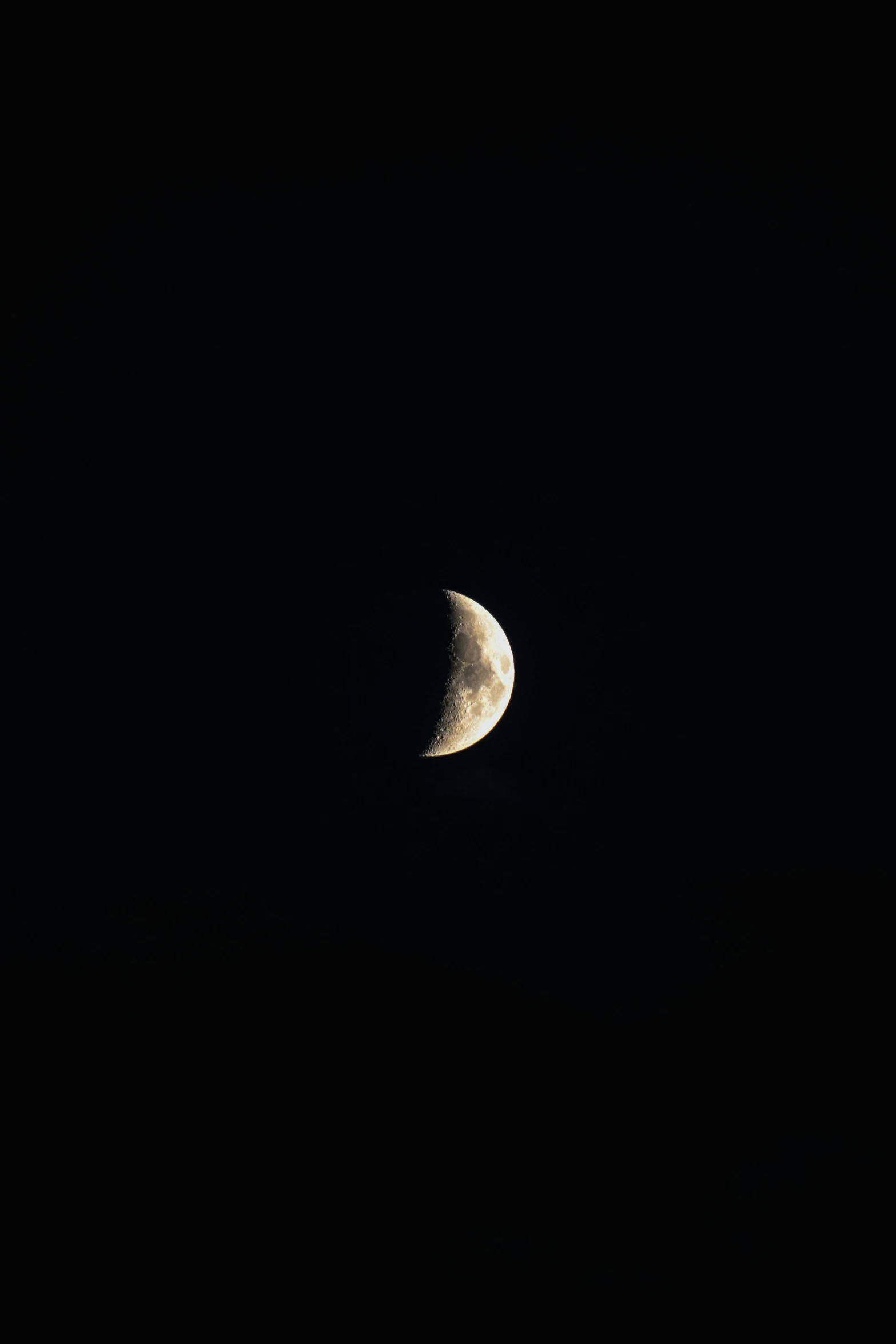 a very dark black sky with a half moon visible