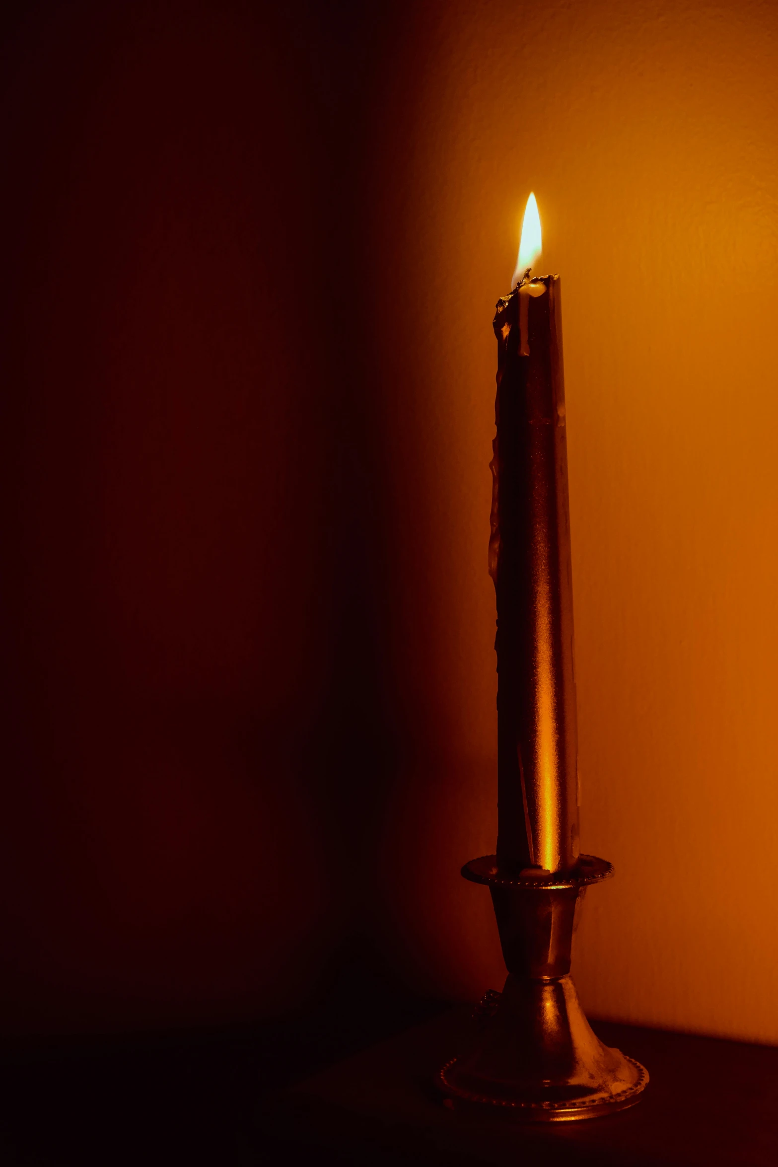 a single lit candle lit on a table