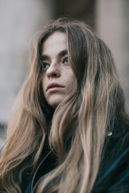 a woman with long hair is staring off to the side