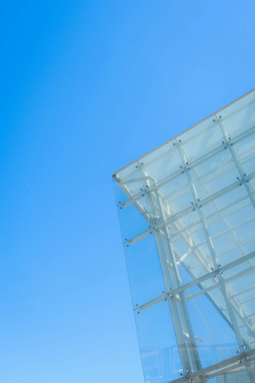 a blue sky with a clear glass structure in the middle