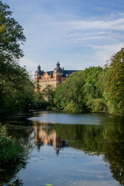 a palace and trees surrounding the water with reflections