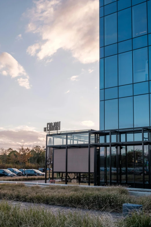 an empty parking lot with cars in front of a tall building