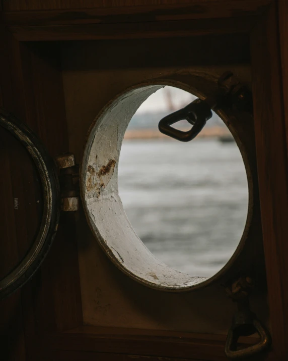 a port hole with an anchor and a handle