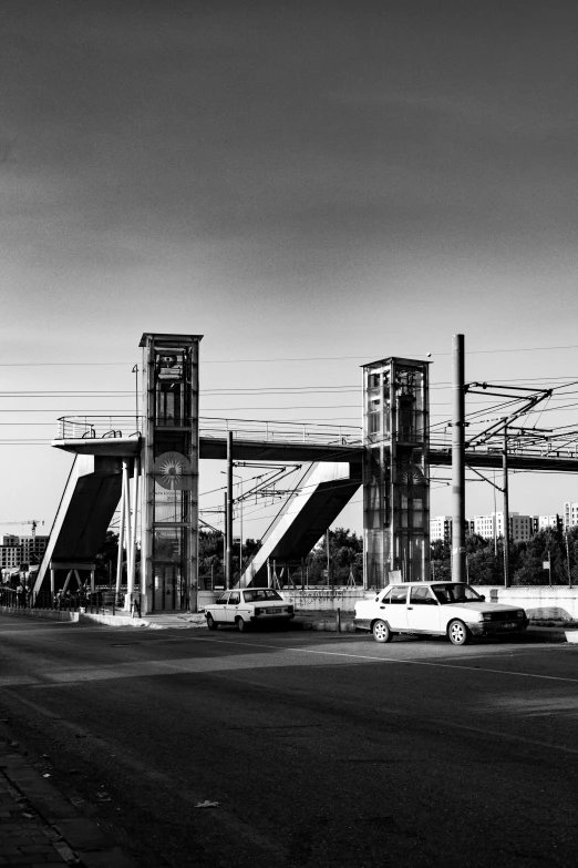 cars are sitting near an industrial zone with a tall clock tower