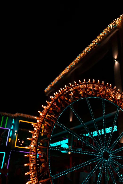 an elaborately lit ferris wheel at night in front of a building