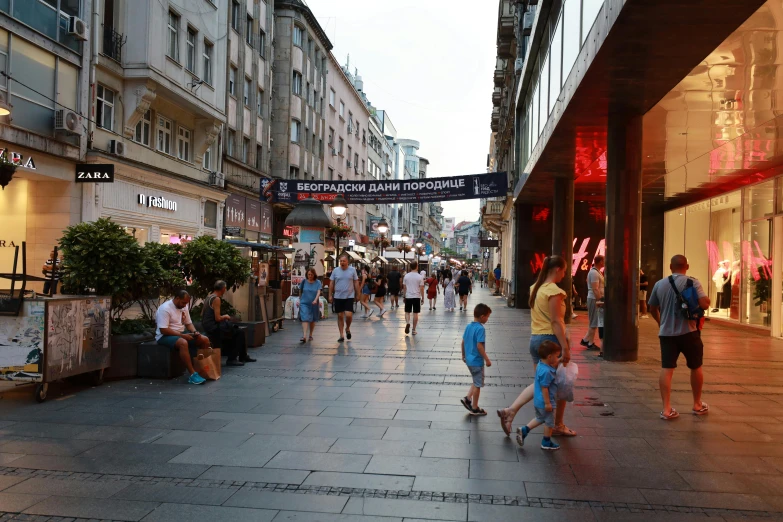 people are walking down the sidewalk in an urban area