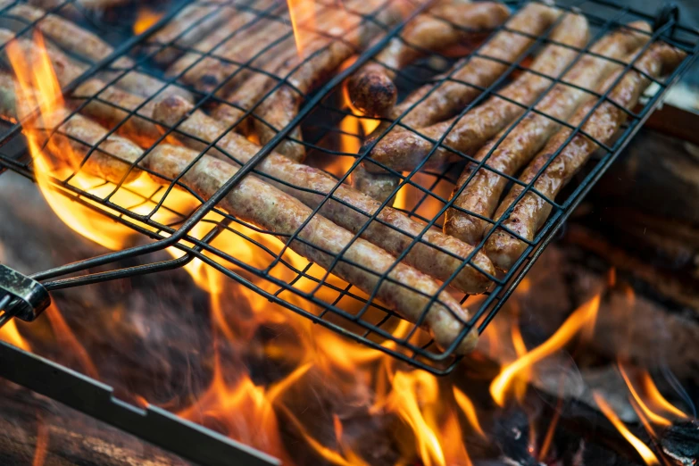 there are several cooked sausages on a charcoal grill