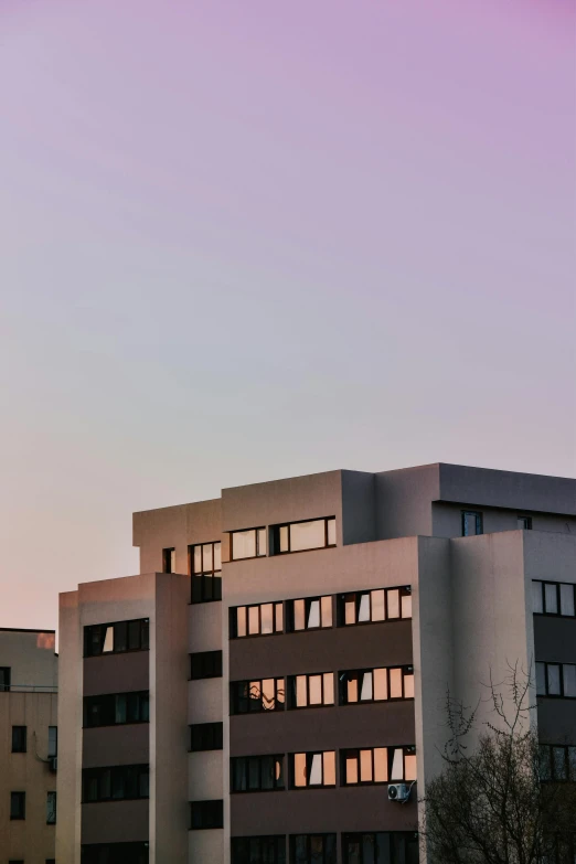 three buildings near each other at sunset, with the evening sun shining in the windows