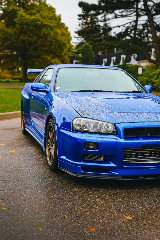 a blue sports car is parked on the side of a street