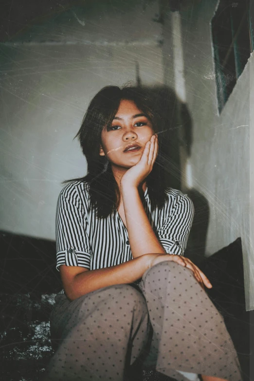 young woman seated on floor in room with unfinished walls