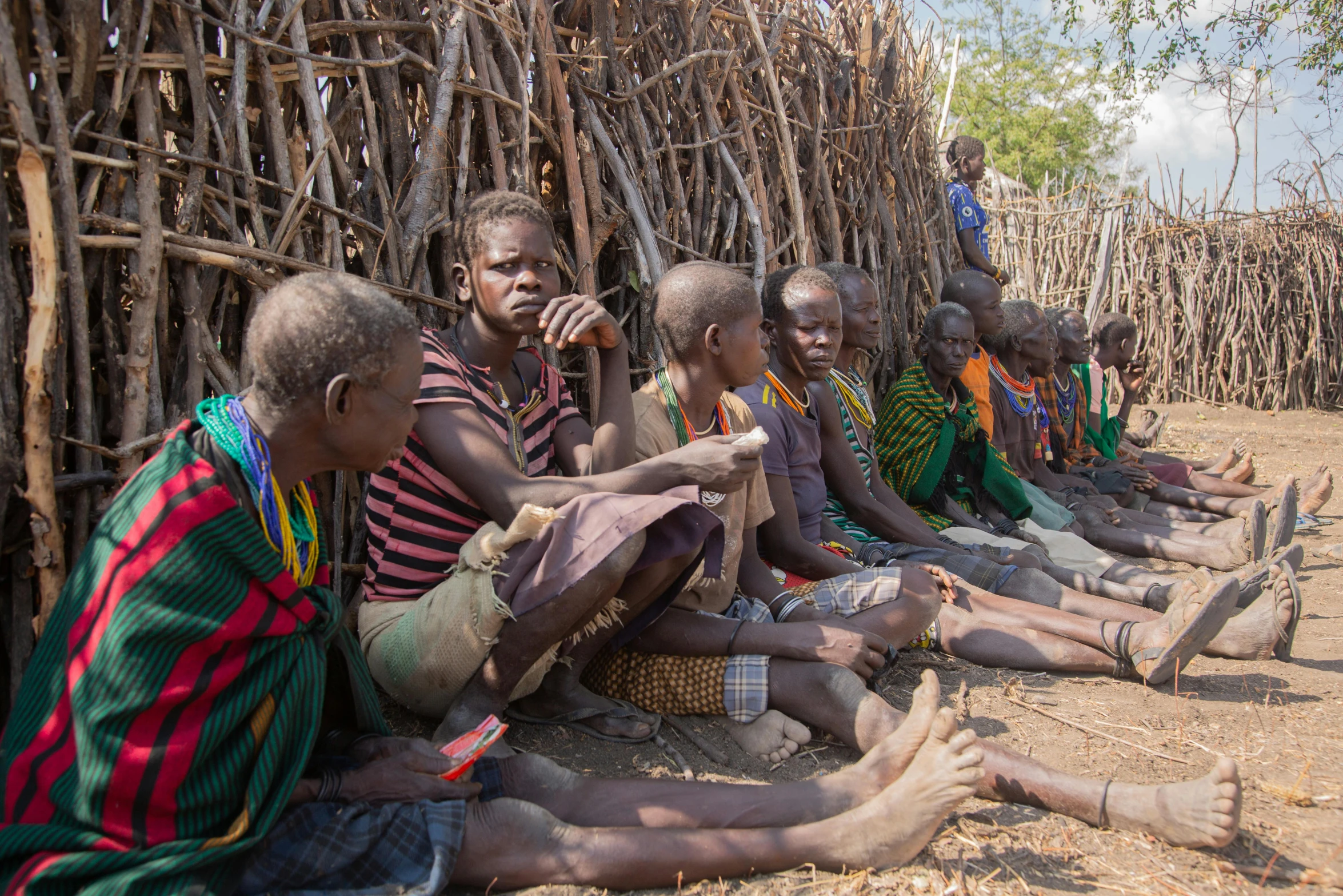 several men sit in front of sticks with fingers on them