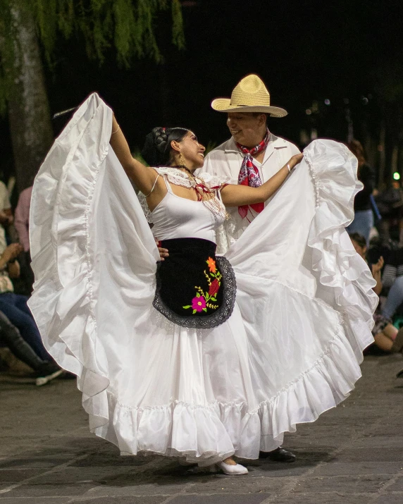 two dancers in traditional costumes perform during a parade