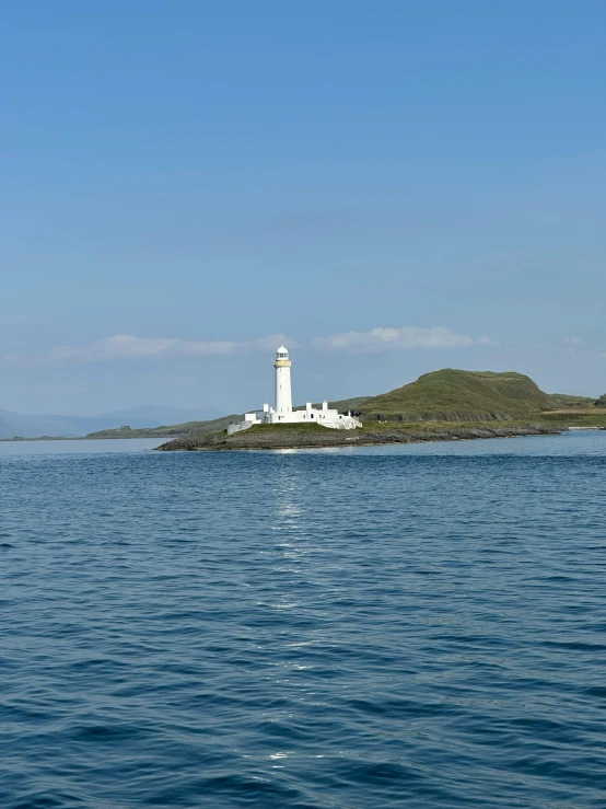 a lighthouse stands near a small island on the coast