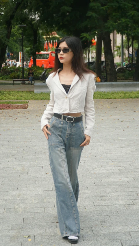 a woman in jeans and a black shirt and sunglasses