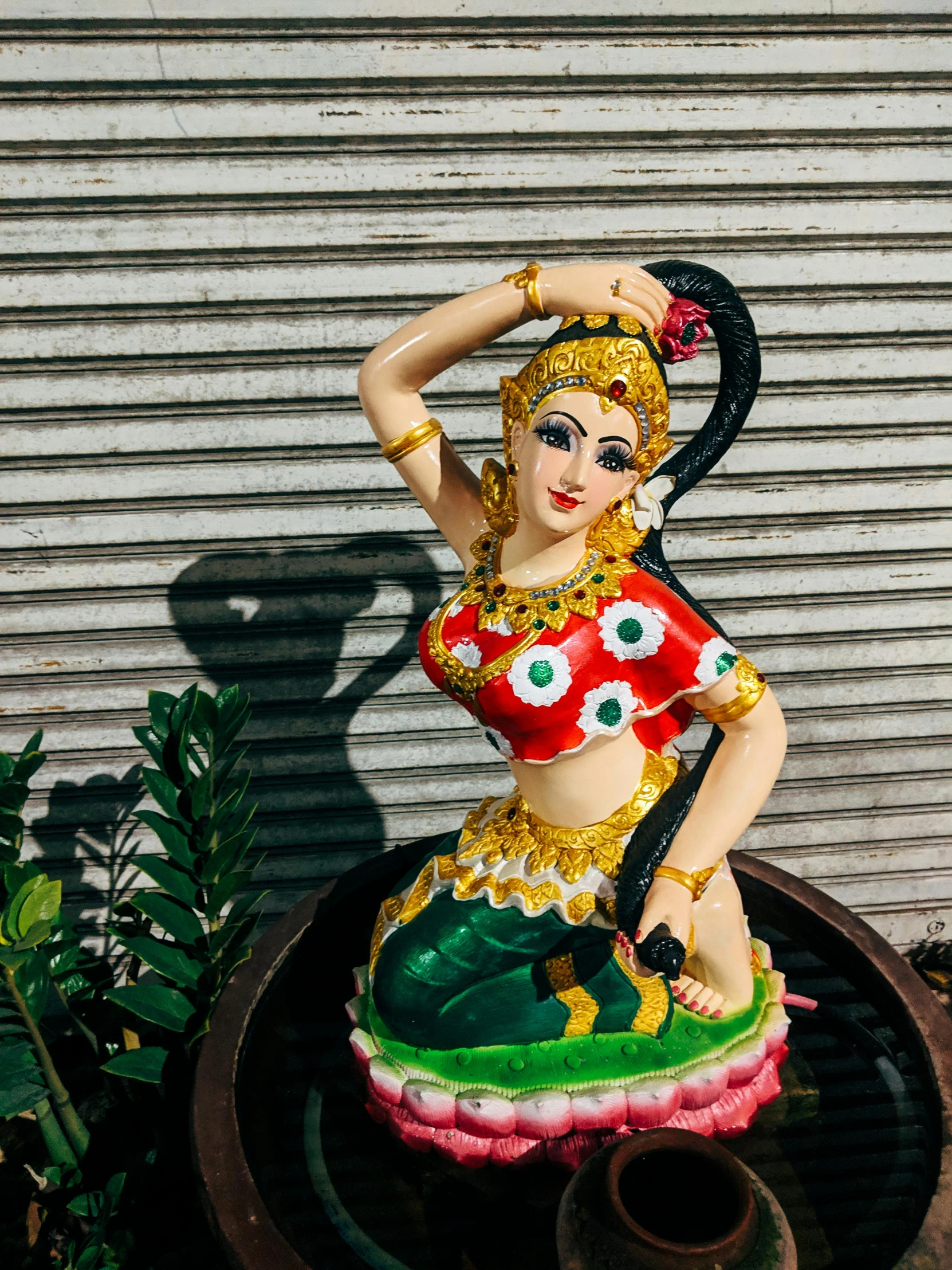 a figurine sitting on top of a large black pot